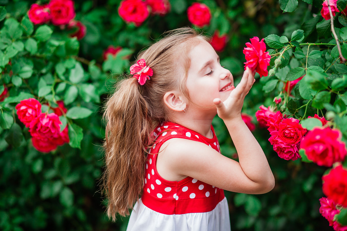 Ребенок нюхает цветок
