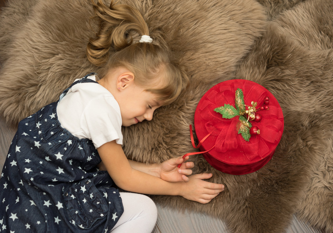 Маленькая девочка лежит на полу с подарочной коробкой - Ирина Вайнбранд