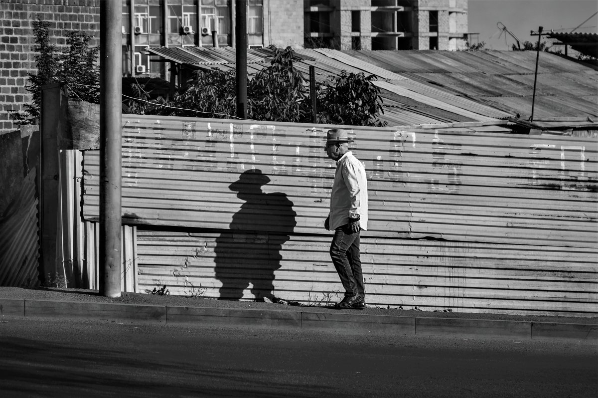 Мужчина в шляпе, идущий вверх по ул. Прошяна - Eugene *