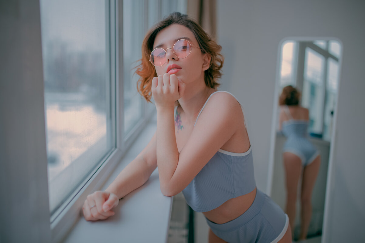Девушка в коротком голубом топе и очках с отражением в зеркале смотрит в камеру - Lenar Abdrakhmanov