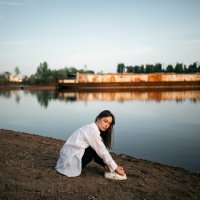 Девушка в белой рубашке и черных брюках сидит на песчаном берегу у реки с заброшенным кораблем :: Lenar Abdrakhmanov