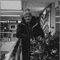 Мужчина за растением в торговом центре :: Николай Чекалин