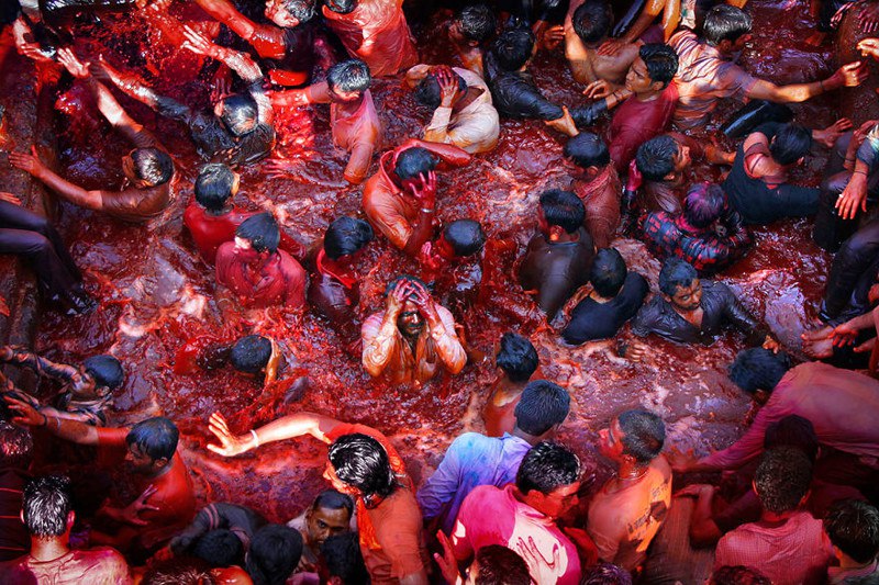 Индусы бросаются в бассейн с окрашенной водой во время праздника красок Холи. Насик, Индия